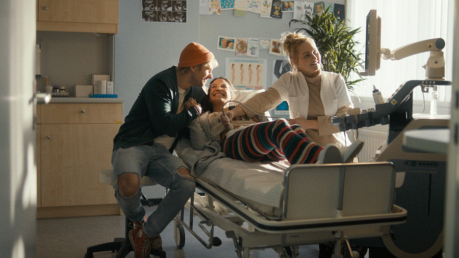 Film still: a joyful, young couple at ultrasonic pregnancy checkup