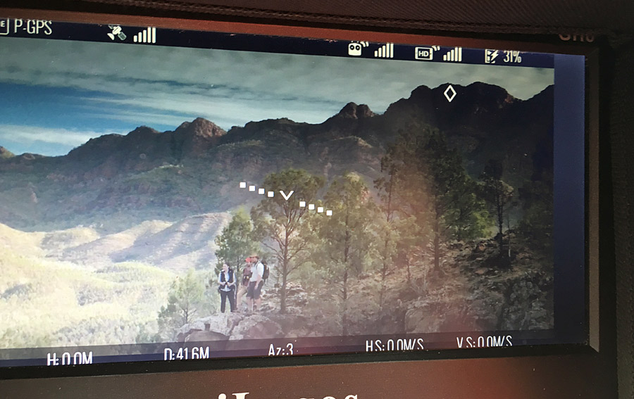 Illustration: A crew scouting views in a mountain valley