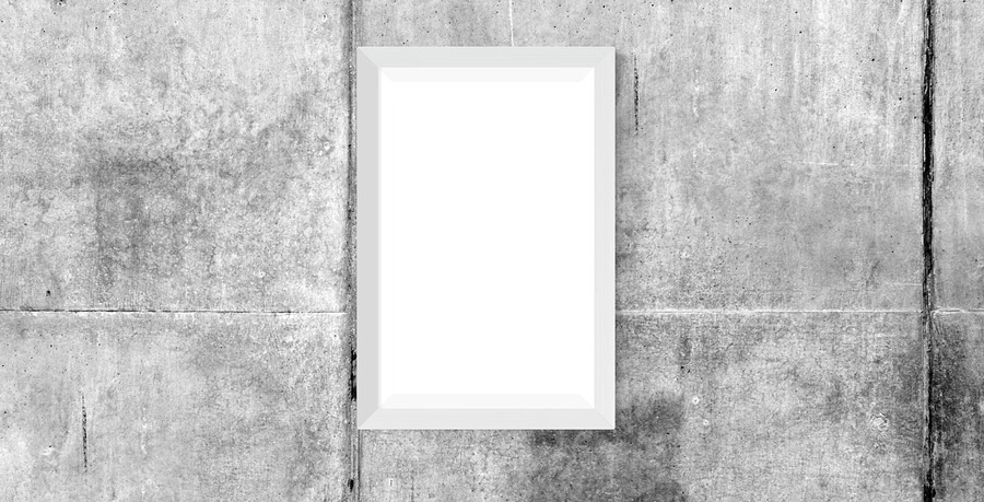 Title photo (black and white): a dark wooden table top in front of a concrete wall, on the wall an empty, white rectangle indicating a picture.