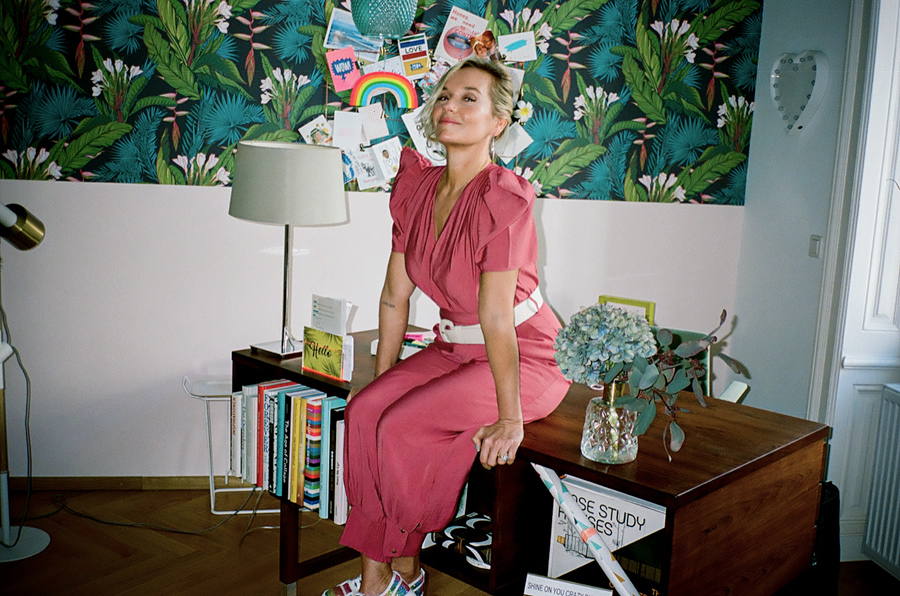 Lisa Scheid, sitting cheerfully on her desk